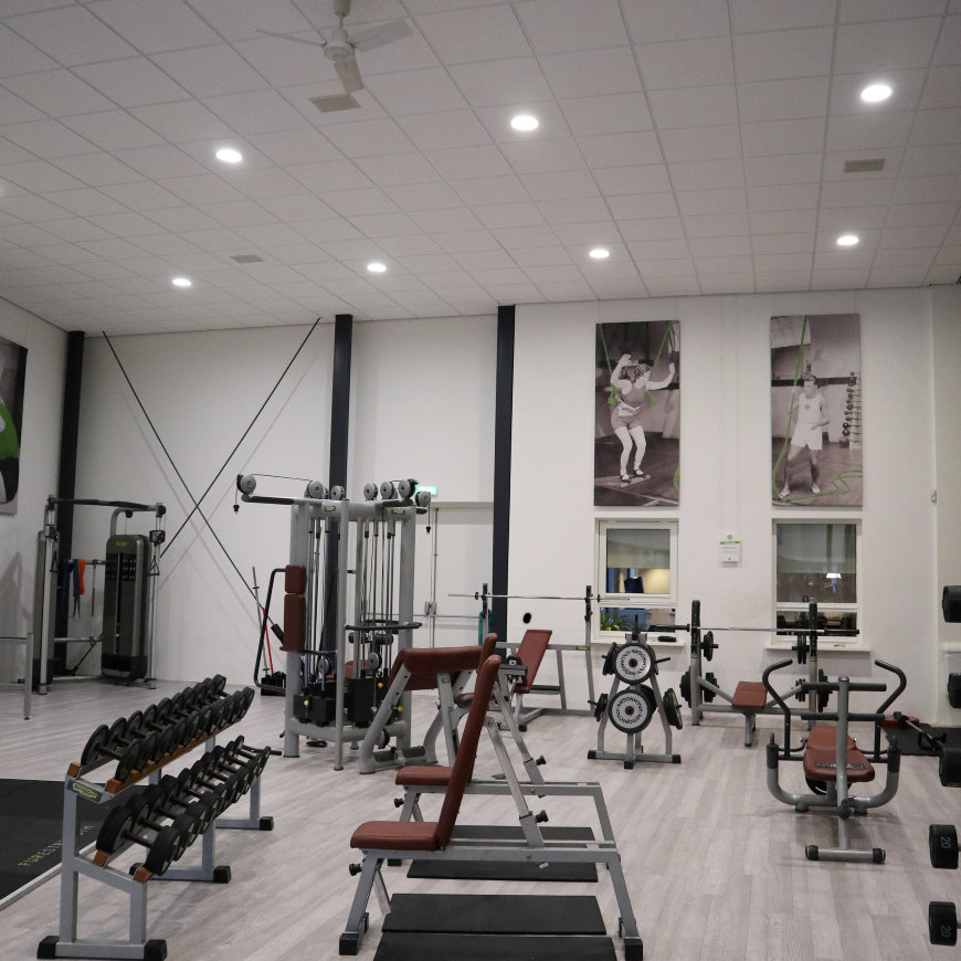 Downlights verlichten een fitnessruimte met krachttoestellen